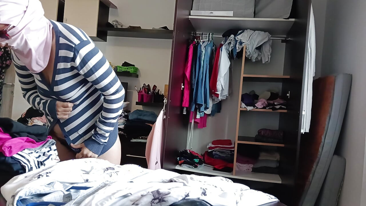 Amaterska žena se zabavlja isprobavajući odjeću i šišajući je