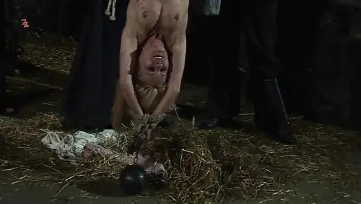 Ведьма висит вверх ногами и поливается чёрным воском