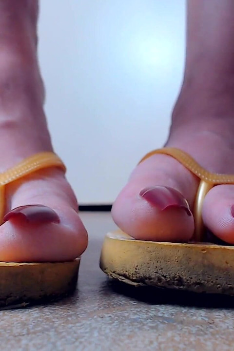 Toenails hanging off yellow flip flops