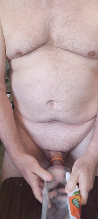 Exhibitionist masturbator testing a new bottle for cock play