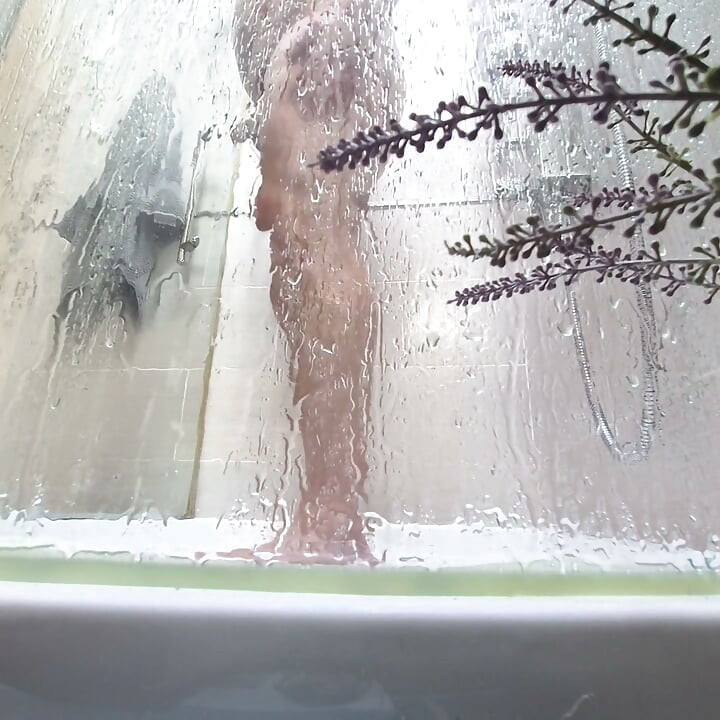 Nagi facet pod prysznicem goli dupę, jaja i kutasa