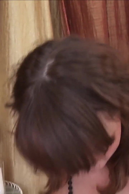 Une jeune femme met une crème sur son corps