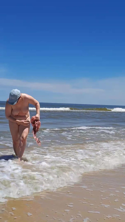 Amateur filming. A nudist plays with waves on the ocean shore. | Clip 1