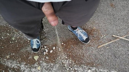 Pissen und kommen im Freien in einem öffentlichen Park