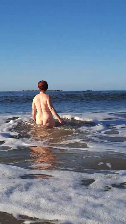 Nudista real jugando desnuda en las olas del océano | Clip 1