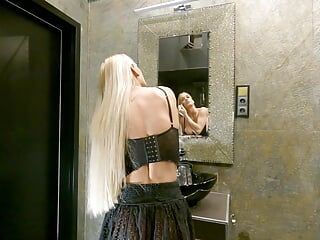 Blonda sexy cu părul lung cu țâțe mari se pregătește pentru noapte într-o fustă mini transparentă cu șosete Underknee și fără chiloți