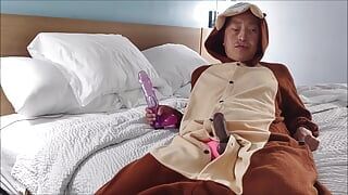 Sucking giant dildo while wearing onesie and pink swimsuit