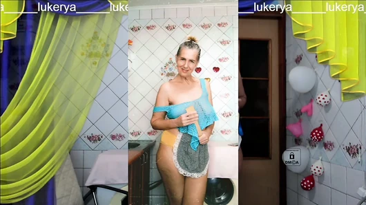 Cheerful Lukerya, as usual, is engaged in erotic cleaning in a transparent mesh on big hanging boobs in yellow panties