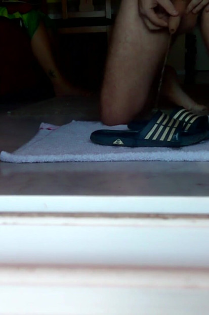 ジョンは床に落ちた入浴用スリッパにおしっこをしている