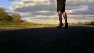 Caminando en medias de red negras de charol y falda ajustada negra