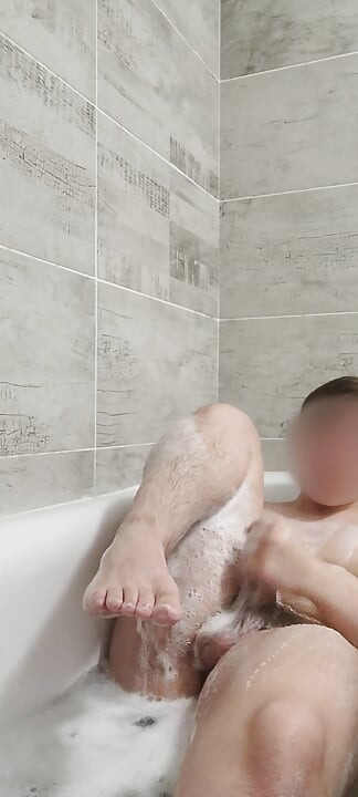 Teen boy playing in bathtub and showing feet