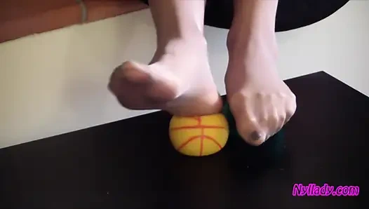 Nyllady drückt Gummibälle und massiert ihre abgespritzten füße