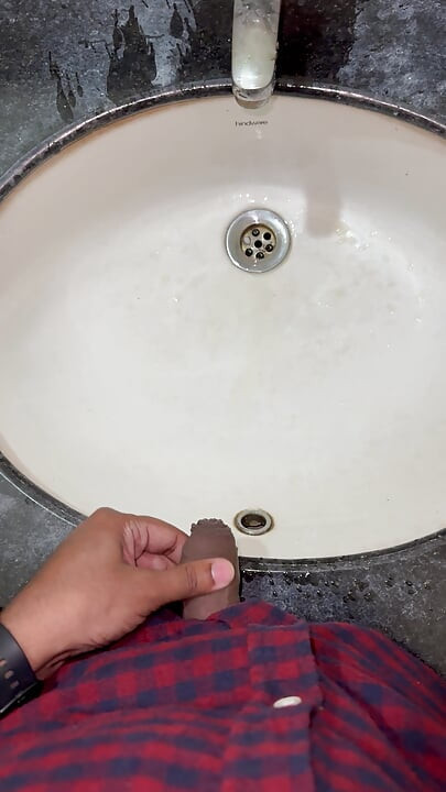 Indijski dečko pokazuje WC školjku i piša