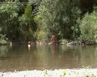 Couple mature naturiste à la rivière