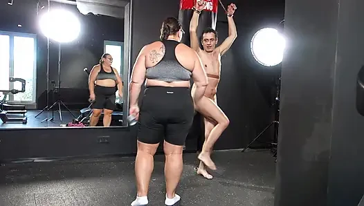 Herrin april praktiziert das boxen auf einem menschlichen boxsack.