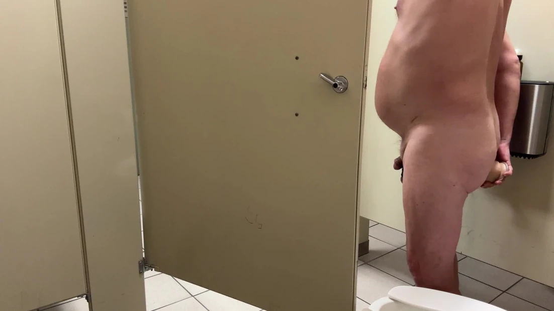 Opened bathroom stall door exposes an exhibitionist dildo fucking