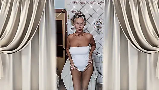 Heiße hausfrau Lukerya flirtet zu hause in ihren weißen dessous.