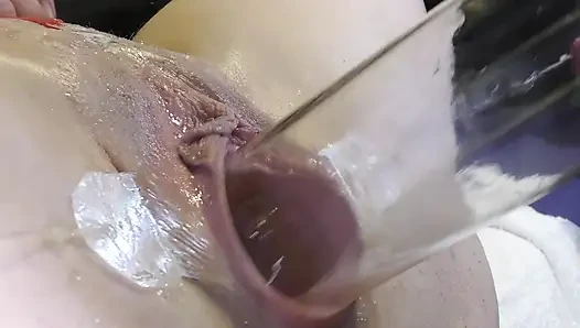 Çok yakından dildo ve camla geniş yayılmış vaginasını sevişmek