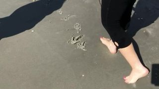 Cunhada em movimento na praia com os pés