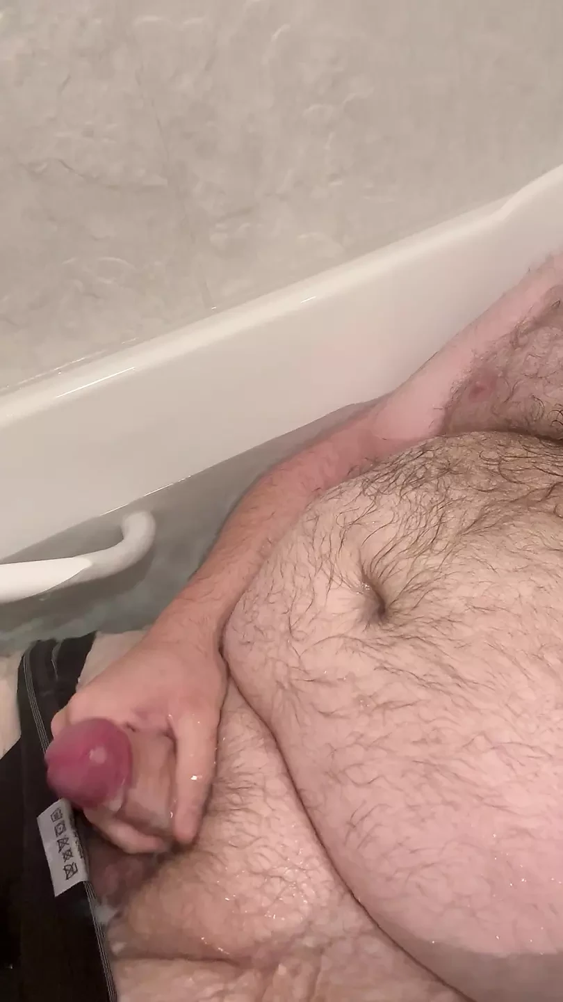 L'orso grasso paffuto gioca con un piccolo cazzo non circonciso nella vasca da bagno
