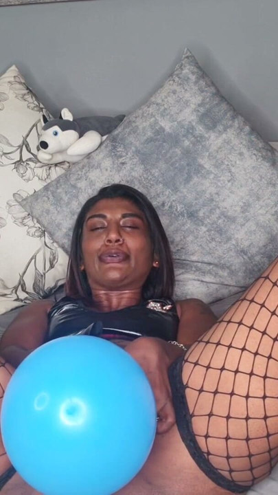 Desi con un sexy traje de látex jugando con globos y hablando sucio | Clip 1