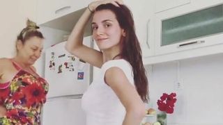 Niet -naakt mooi meisje danst in haar keuken