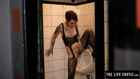 Mädchen pinkelt und masturbiert in einem Urinal eines öffentlichen Zimmers der Männer