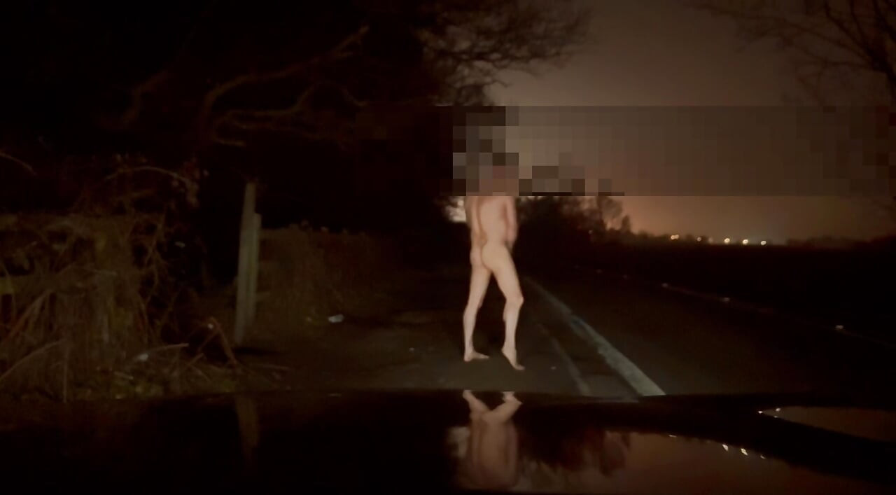 Crazy naked exhibition barefoot with cars passing close