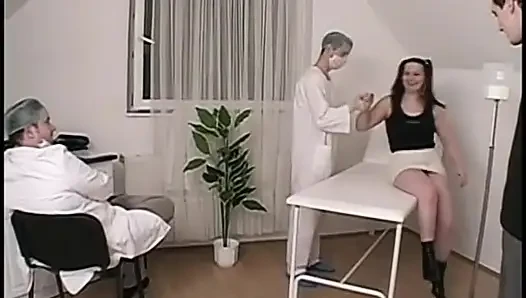 Girl in ponytails kneels to suck off a surgical masked doctor