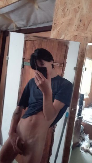 Jovem cara com tesão masturba seu pau na frente do espelho