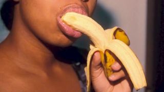 Une black coquine aux lèvres sexy joue avec une banane