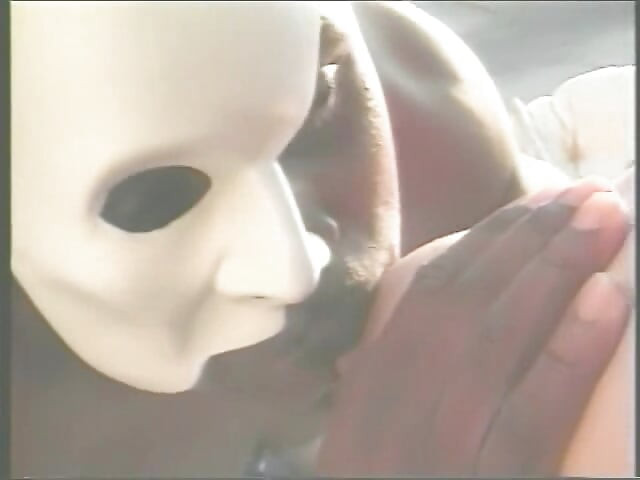 Muscular Stranger in White Superhero Mask Drills Ebony Chick on the Parking of Shopping Mall