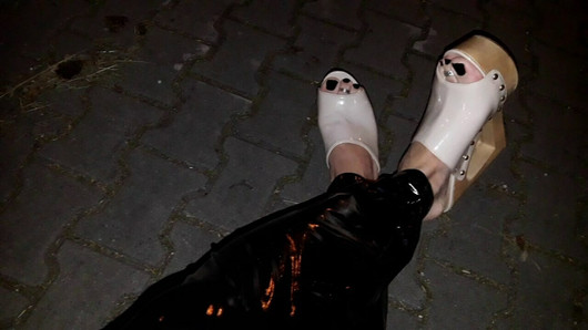 crossdresser on the street in latex leggings and high heels