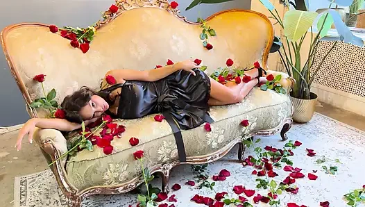 Schöne monika fox im schwarzen kleid auf sofa mit rosen