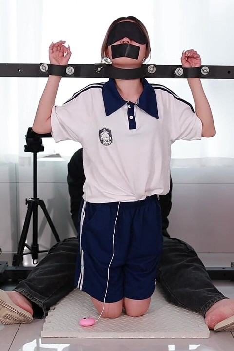 A Girl with a Metal Gag in Place, Playing with Her Tongue