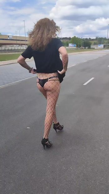 Uma garota trans magra mostra sua bunda em público.