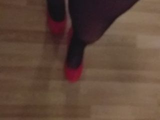 Mistero trans che cammina in calze lucide rosse con tacchi altissimi