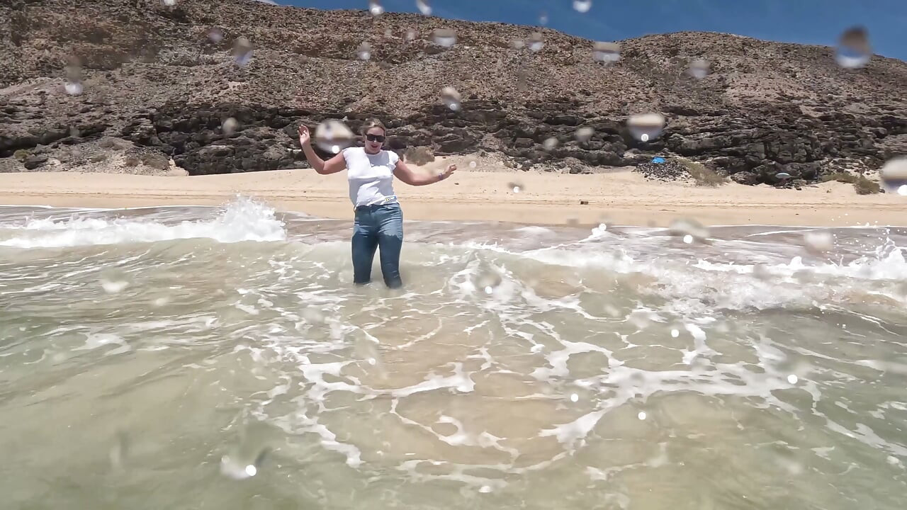 Ragazza Che Bagna I Jeans Nell'oceano E Nuota Con Una Maglietta Bianca Bagnata