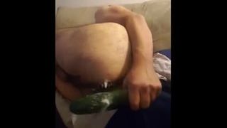 Behaarter unterer Junge spielt mit 8 Zoll Zucchini