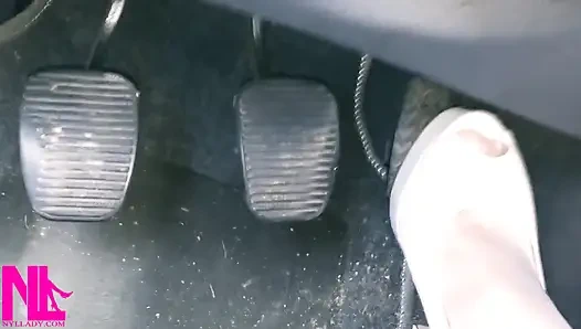 Revving und verrücktes Pedalpumpen in weißen strümpfen und weißen sandalen mit hohem absatz,