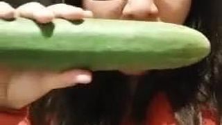 Een dikke teef plaagt, neemt een komkommer