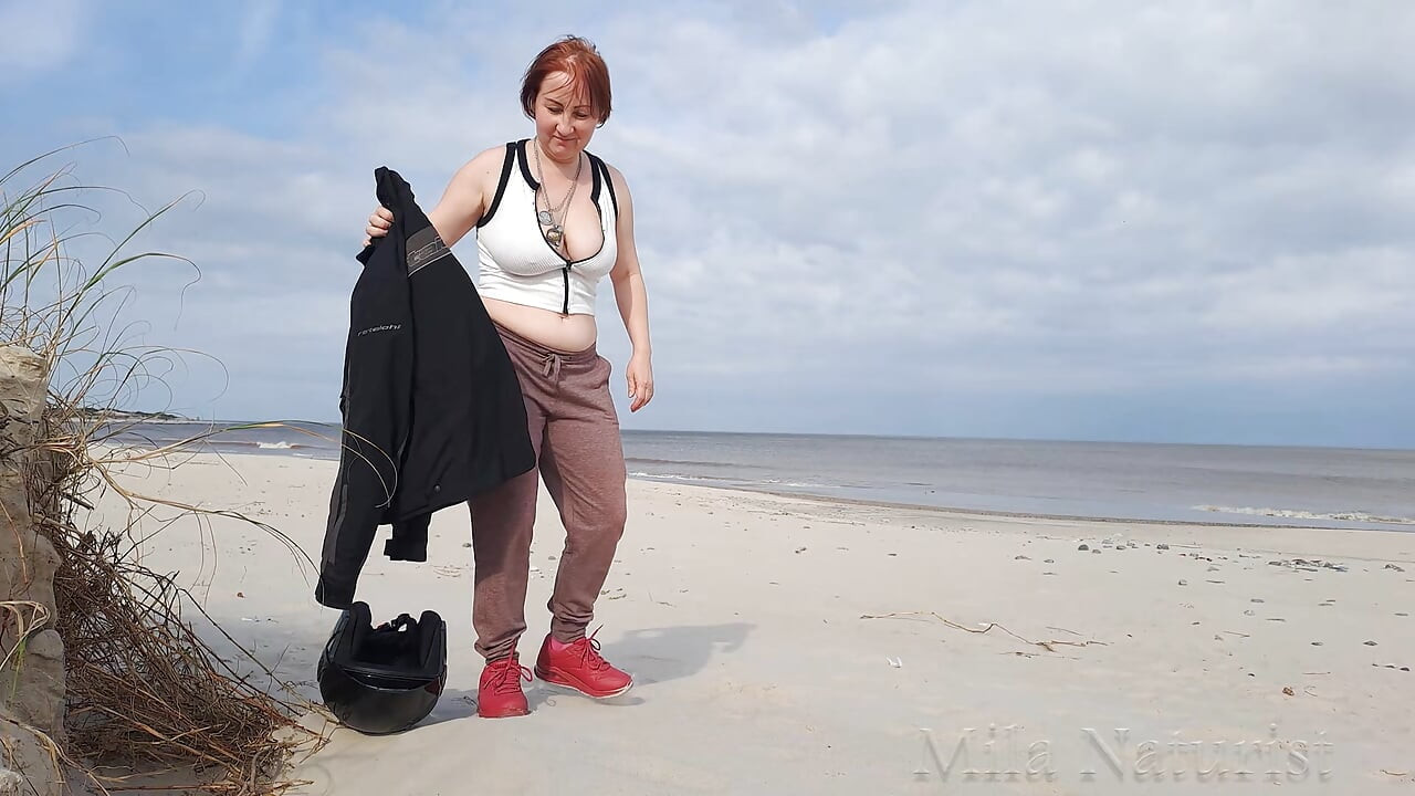 A biker girl strips naked and masturbates on a wild beach.