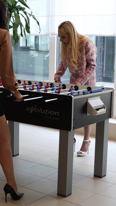 Des matchs de baby-foot amusent les filles pendant les pauses au bureau de rencontre freelove.