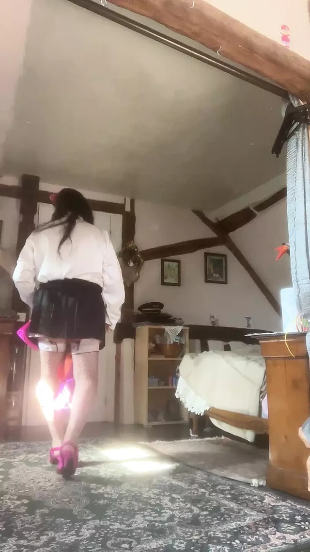 In black pleated mini skirt and white blouse