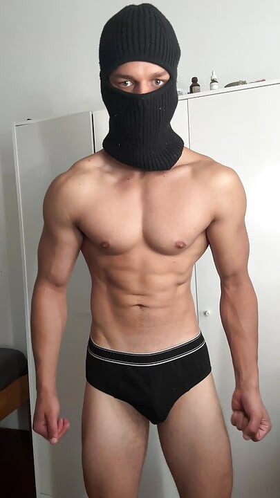 Masked young hunk showing off his muscles
