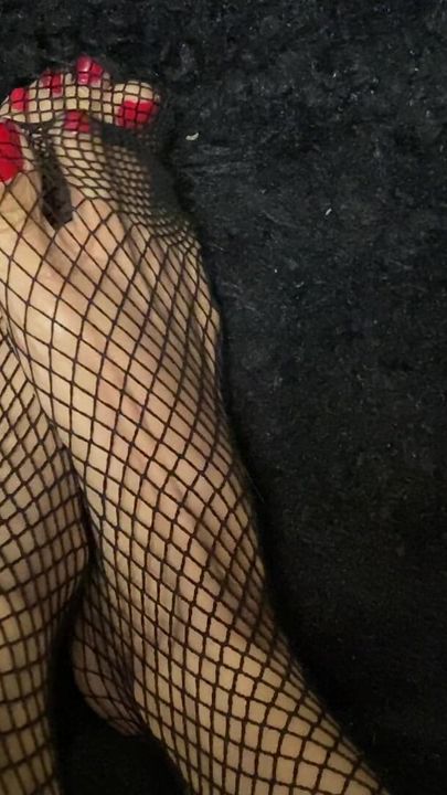 Fishnet stocking with sexy feet in red nail polish