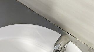 Рискованная писсинг в раковине в общественном туалете