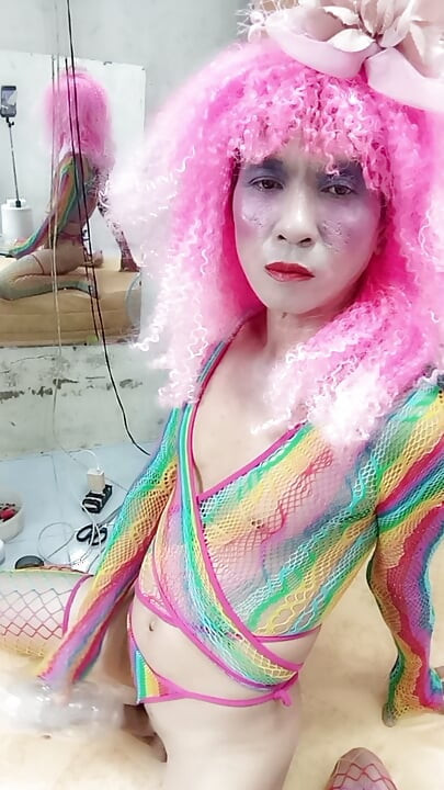 Transgender Le veste-se de forma sensual e brinca com copos de sexo. Peitos artificiais