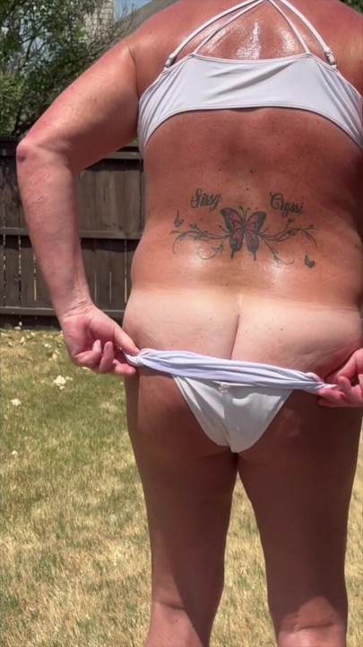 Sissy Cryssi in her pink bikini with a goof view of the tan lines and her big fat ass