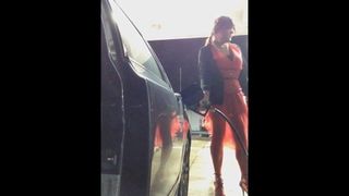 風の強い日に赤いドレスを着たガソリンスタンド